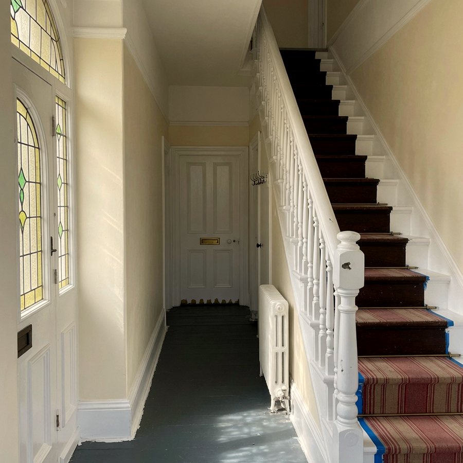 Painted hallway and staircase with cream walls and white spindles